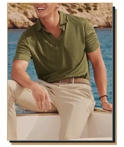 Man sitting on a boat wearing an olive green linen-blend polo shirt from Charles Tyrwhitt tucked into beige chinos with a suede belt