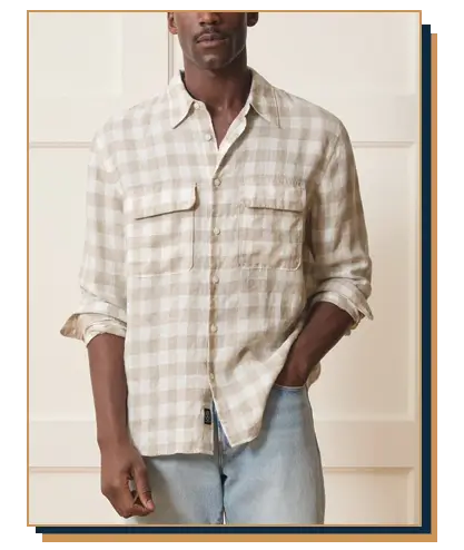 Man wearing a Todd Snyder beige and white gingham check linen button-down shirt with chest flap pockets paired with light wash jeans
