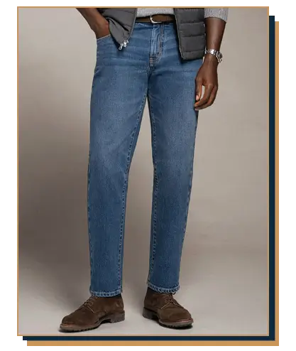 Man wearing medium-wash straight-leg blue jeans, brown suede boots, and a grey vest from Proper Cloth