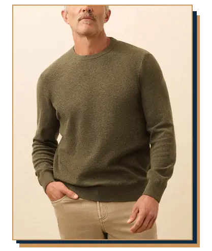 Man wearing an olive green donegal crew neck sweater from Faherty paired with khaki chino pants