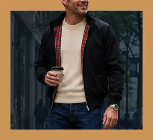 Harrington-Jacket Man wearing a black G5 Apparel Harrington jacket with a red plaid lining over a beige sweater and blue jeans.